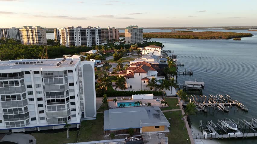 Aerial of Fort Meyers Beach Florida at sunset.  Pull drone shot of dock, waterway and condos.