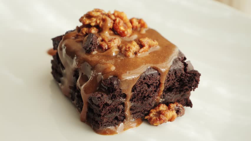 Caramel sauce on chocolate hazelnut brownie close up. 