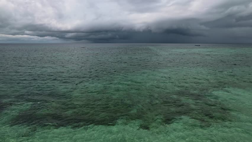 Turquoise water and dark cloudy sky over Maratua Island, Indonesia.