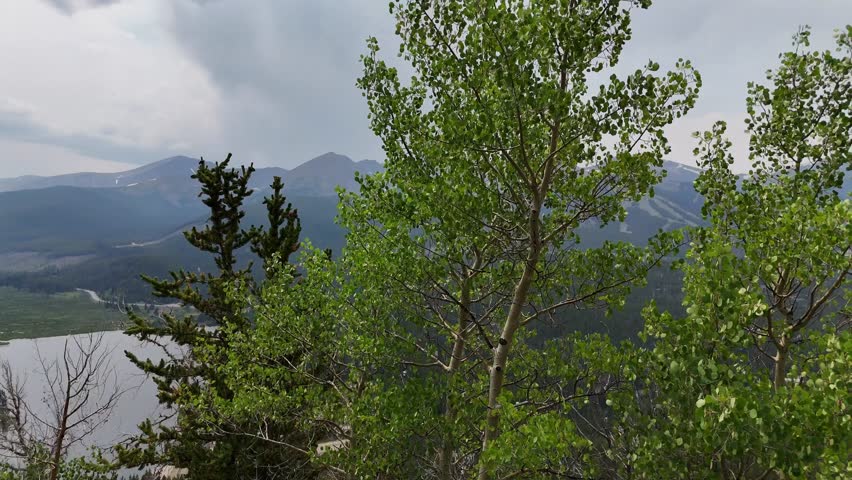 Breckenridge Colorado Aerial Drone shot in summertime.  Rain approaching in the distance in mountains, rising above trees.