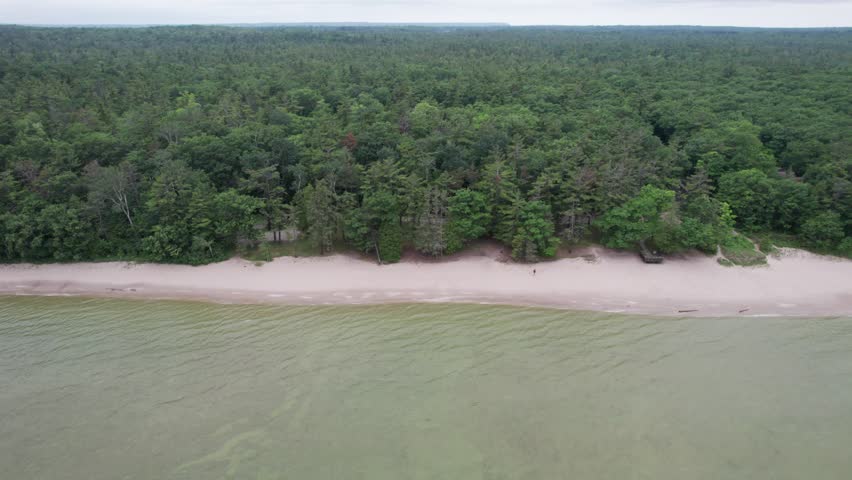 Birdseye rising drone shot of beach, waves and rocks.  Northern Door County Wisconsin.