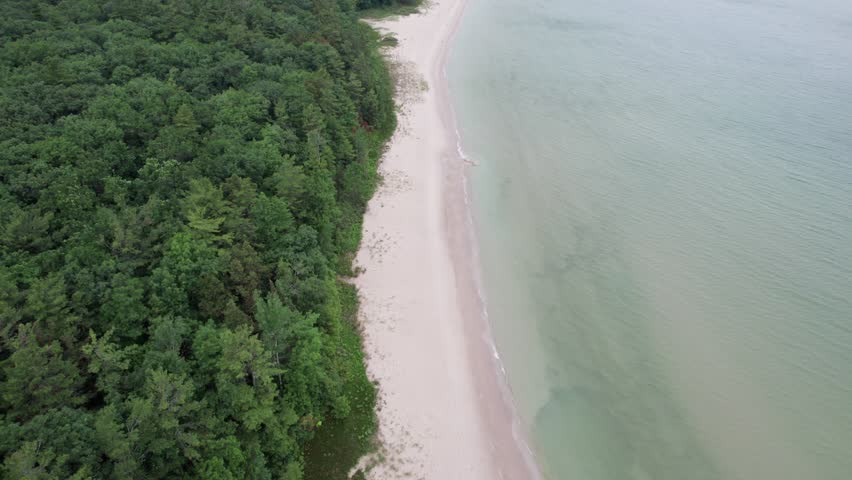 Drone shot of Northern Door County Wisconsin on summer overcast day.  Tree lined beach.