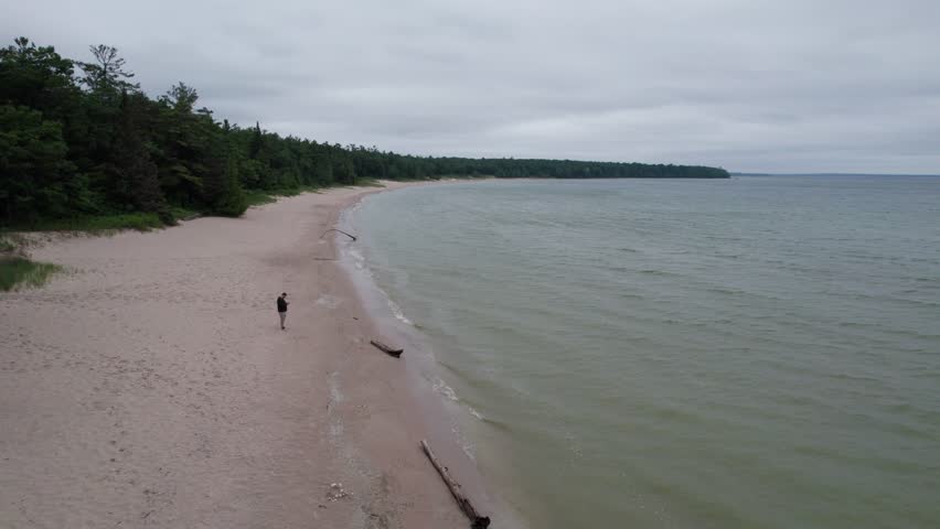 Push Drone shot of Europe Lake in Northern Door County Wisconsin on summer overcast day.  Tree lined Calm Water.