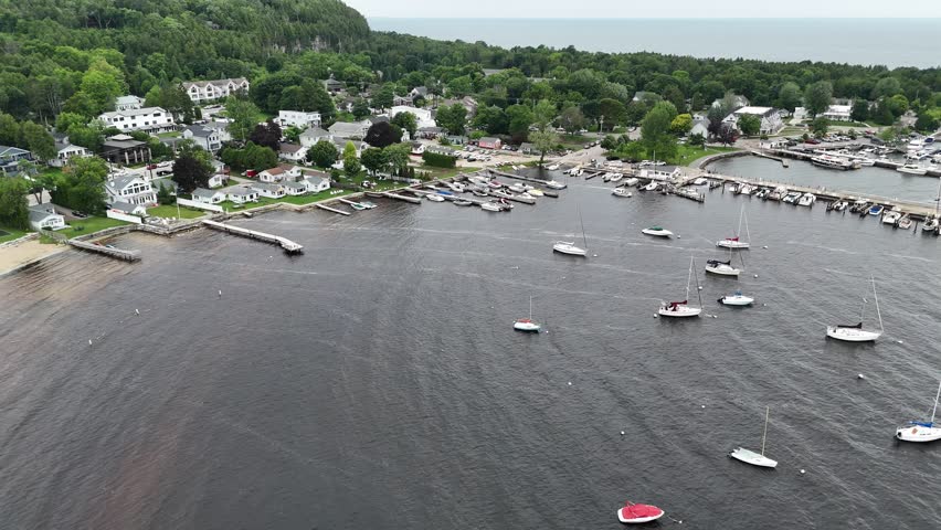 Aerial of Fish Creek in Door County Wisconsin on an overcast day.  Dynamic rising drone shot of marina and boats below.