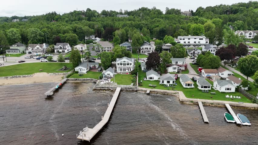 Aerial of Fish Creek in Door County Wisconsin on an overcast day. Right to left drone shot over marina, beach and townscape.