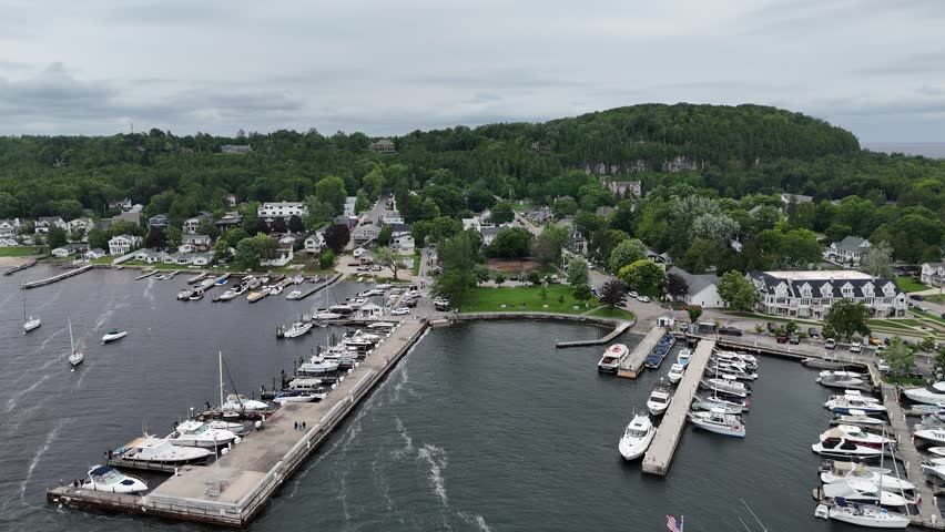 Aerial of Fish Creek in Door County Wisconsin on an overcast day.  Right to left drone shot over marina and townscape.