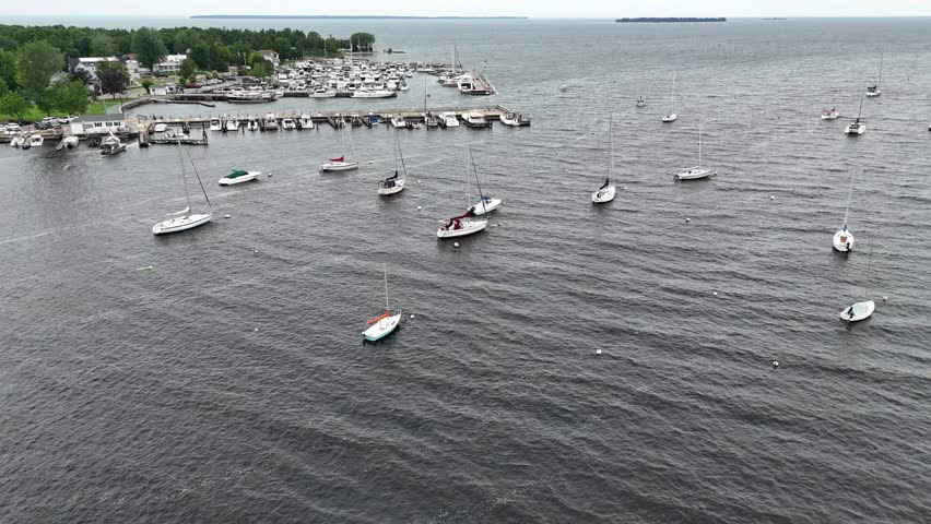 Aerial of Fish Creek in Door County Wisconsin on an overcast day.  Drone push shot of boats in the harbor with an Island in the distance. 