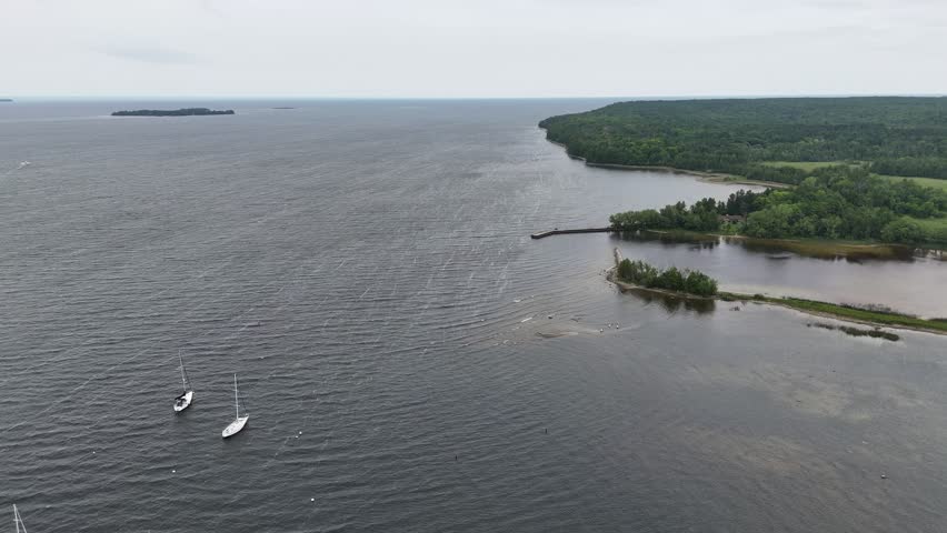 Aerial of Fish Creek in Door County Wisconsin on an overcast day.  Drone shot of Lake Michigan with islands, waves and boats.