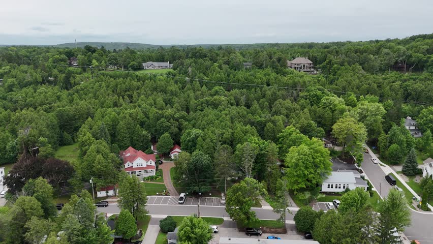 Aerial of Fish Creek in Door County Wisconsin on an overcast day.  Drone push shot of homes on bluff and hills in the distance.