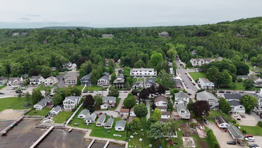 Aerial of Fish Creek in Door County Wisconsin on an overcast day.  Drone Push shot over town with hilly terrain in the distance.