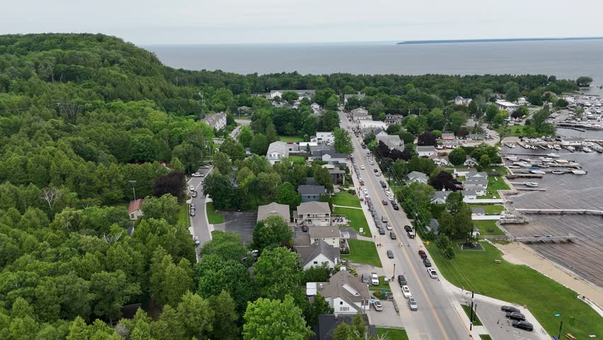Aerial of Fish Creek in Door County Wisconsin on an overcast day. Drone push shot of Main Street traffic and bluff.