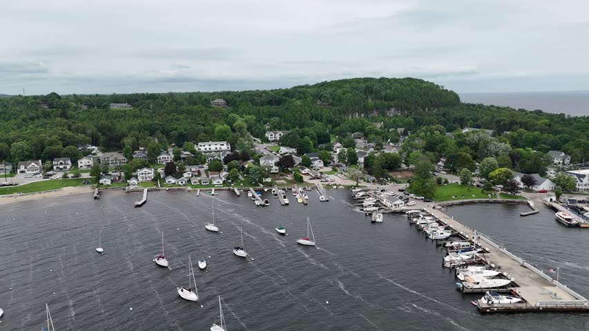 Aerial of Fish Creek in Door County Wisconsin on an overcast day.  Rising drone shot over marina looking directly at Bluff.