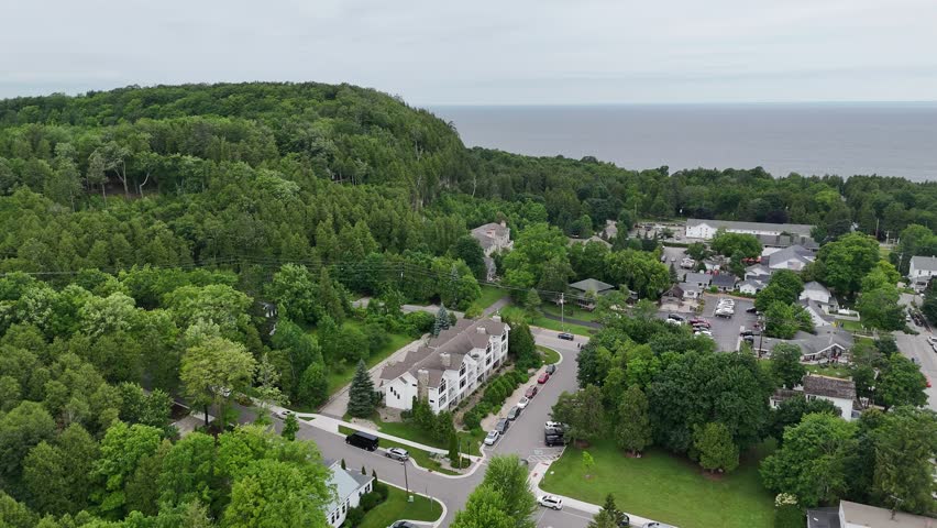 Aerial of Fish Creek in Door County Wisconsin on an overcast day.  Push drone shot towards bluff and town.
