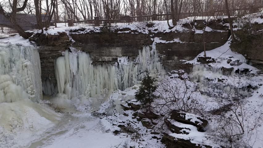 Low Drone Orbital shot of Frozen Waterfall in Green Bay Wisconsin.