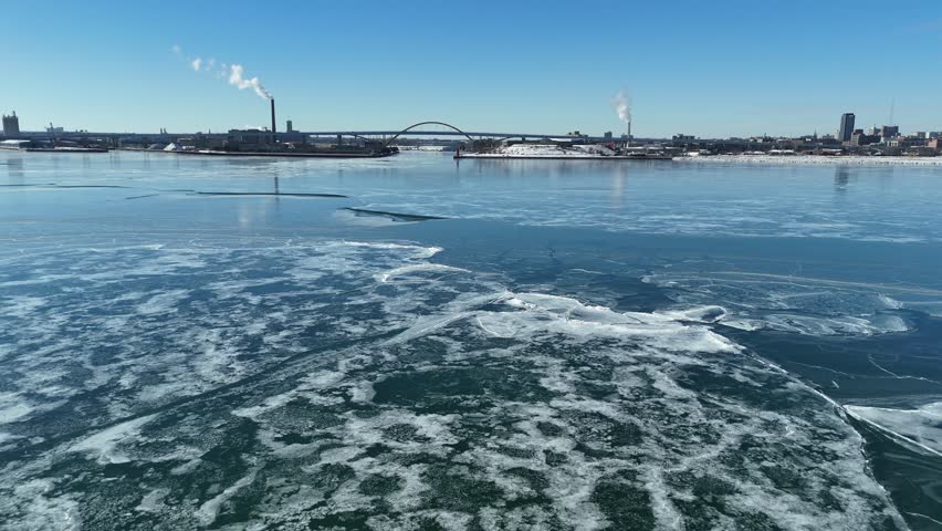 Winter Aerial in Milwaukee Wisconsin on the frozen shore of Lake Michigan.  Long push shot of blue ice.