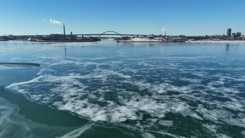 Winter Aerial in Milwaukee Wisconsin on the frozen shore of Lake Michigan.  Low shot of ice formation on blue surface.
