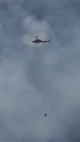 Helicopter Carrying Water Bucket Fighting Forest Fire in Hope, British Columbia, Canada
