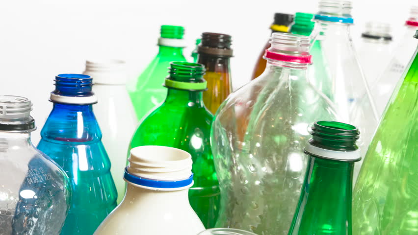 Assorted Bottles for Recycling. HD Footage Looped. A close-up of colorful plastic bottles of different shapes and sizes slowly moving in a chaotic arrangement against a clean white background. Perfect for themes of recycling, sustainability, or environmental awareness