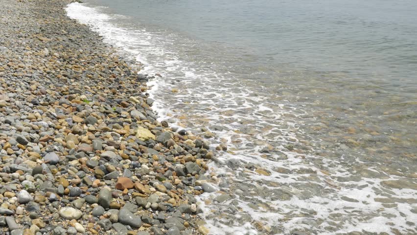 Slow motion: Ocean waves crashing onto a pebble beach in Dalian, China.