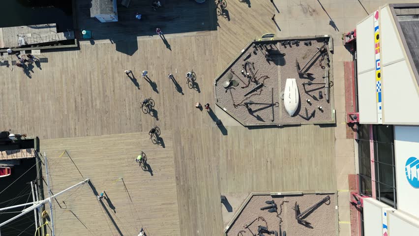 Aerial view of tourists cycling along the scenic Halifax boardwalk near the Atlantic Ocean. Sunlight, ocean breeze, and vibrant city life fill this moment of Canadian summer joy.