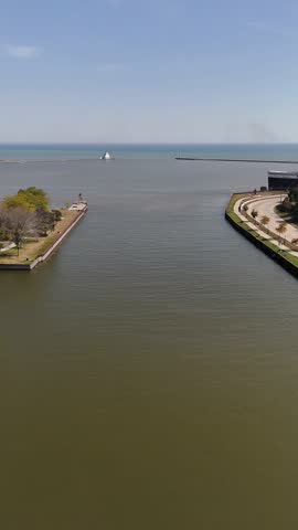 Pulling drone shot of river feeding into lake.  Breakwater and lighthouse in the distance.  Aerial of Downtown Manitowoc Wisconsin USA on a Bright Sunny Day.