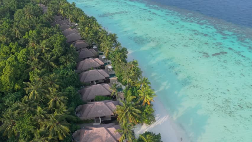 Aerial view of Maldives island resort, showcasing overwater bungalows and pristine beaches