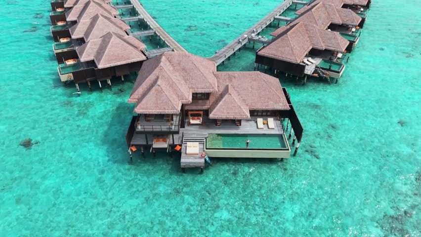 Aerial view of overwater bungalows in the Maldives, showcasing private pools and serene turquoise waters