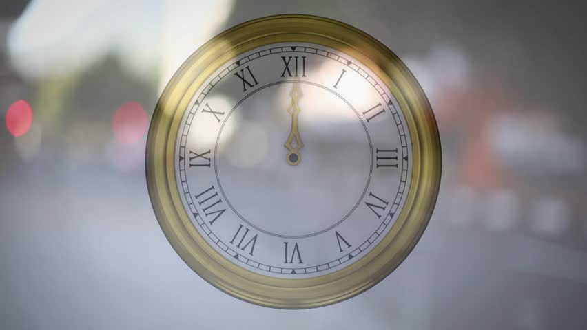 Clock appearing over blurred road, gold rim Roman numerals, hands moving clockwise indicating time. Timepiece, urban, bokeh, reflections, parallax, daylight, cars