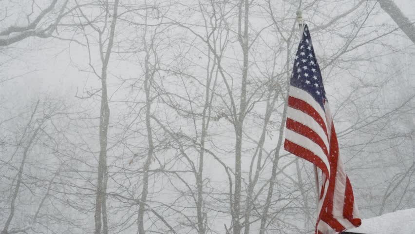 Smooth slow motion around a waving flag during a blizzard.