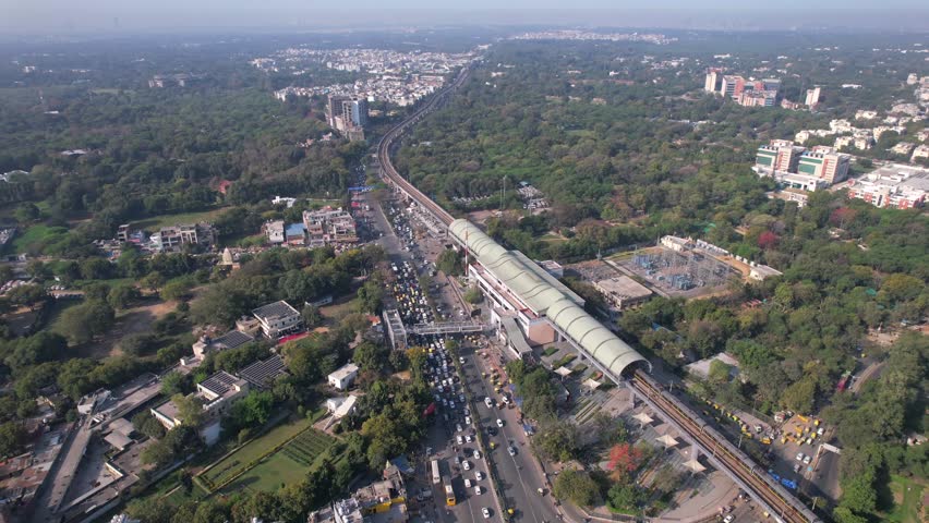Aerial view of Delhi Metro with road traffic at Chhatarpur Metro Station, New Delhi, India