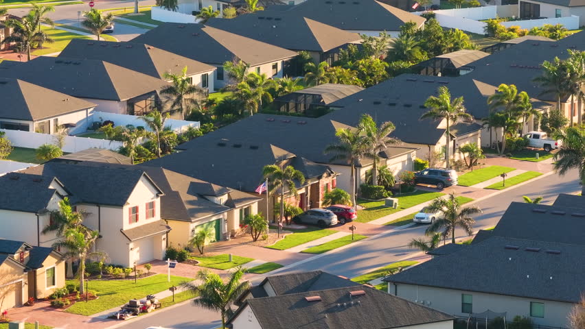 Gated community with expensive houses between green palm trees in southwest Florida. Premium housing development in the USA.