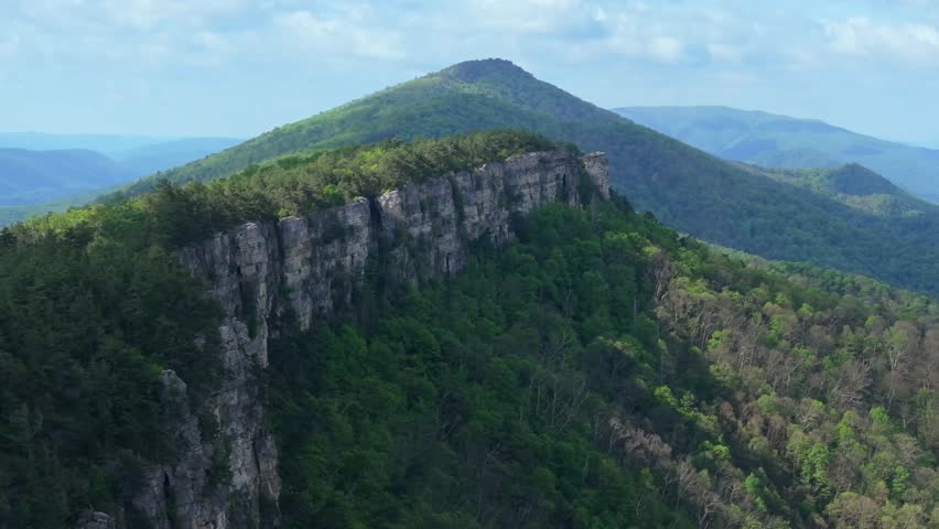 High aerial medium orbit of dramatic cliff edge and expansive forested valley at Chimney Top West Virginia