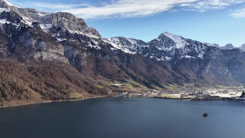 Aerial view of Churfirsten mountains overlooking Walensee lake and Walenstadt village in Switzerland.