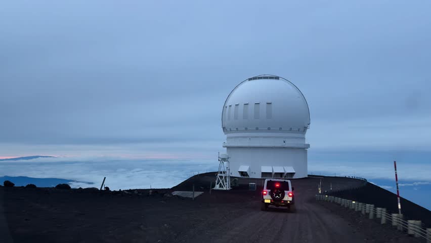 Forward view from a vehicle driving toward Mauna Kea observatory above clouds