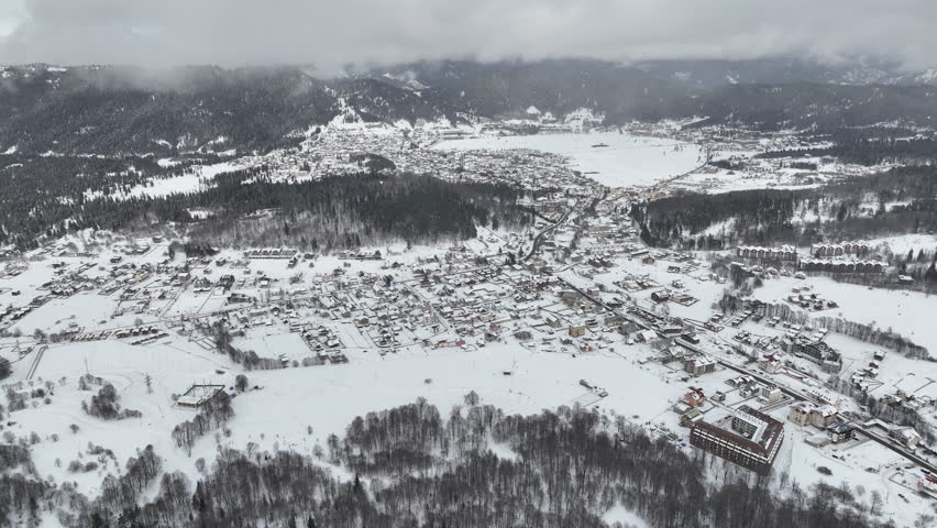 Aerial view of Bakuriani winter resort town with hotels and snow-covered mountains, Georgia