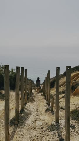 Woman and Dog Walking Along Wild Ocean Path.

Woman walking with her dog along a wild coastal path with open ocean views.