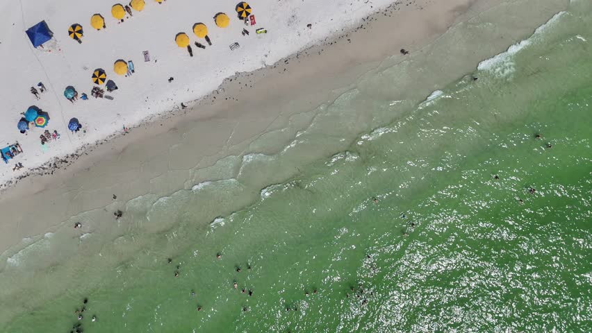 Top-down aerial drone footage of waves washing onto the sandy shoreline at Daytona Beach, Florida.