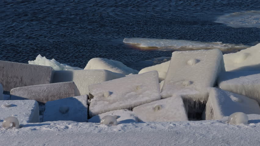 Harsh freezing temperatures envelop angular concrete structures beside tumultuous ocean waters