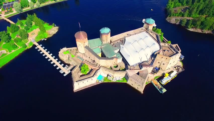 Aerial view of Olavinlinna Medieval Castle in Savonlinna, Finland. Beautiful summer landscape with blue lakes and clear sky
