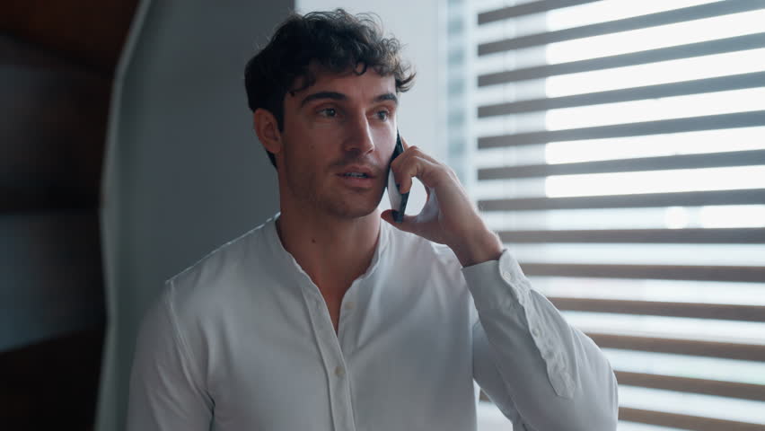 Caucasian business man walking in office talking mobile phone call confident businessman male guy walk indoors talk smartphone discuss work negotiation executive go in company communicate cellphone