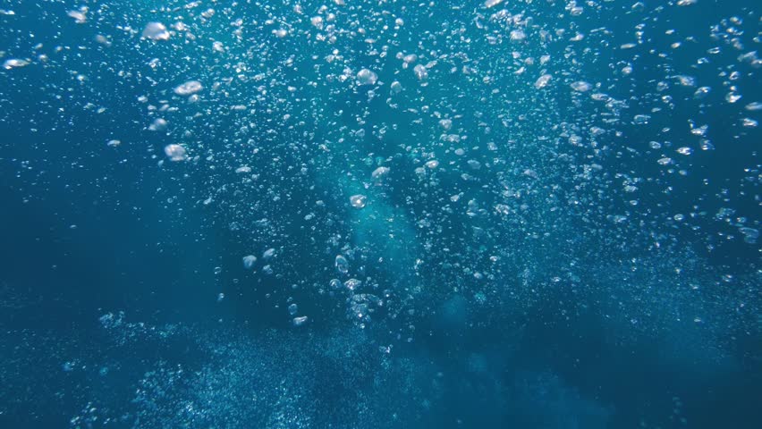 
Cinematic slow-motion view traveling through underwater bubbles in the open ocean. Textured blue water and floating air particles create a relaxing marine scene.