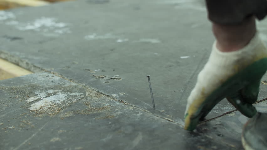Worker hammering nail into wooden formwork during construction