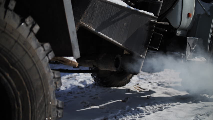 Construction vehicle exhaust emitting smoke in winter conditions