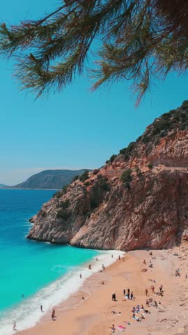 The famous "Kaputas Beach". Excellent nature and sea. People entering the sea and the beach. Beach umbrellas and sun beds. View of the beach from above. Kas region, Antalya, Turkey. 