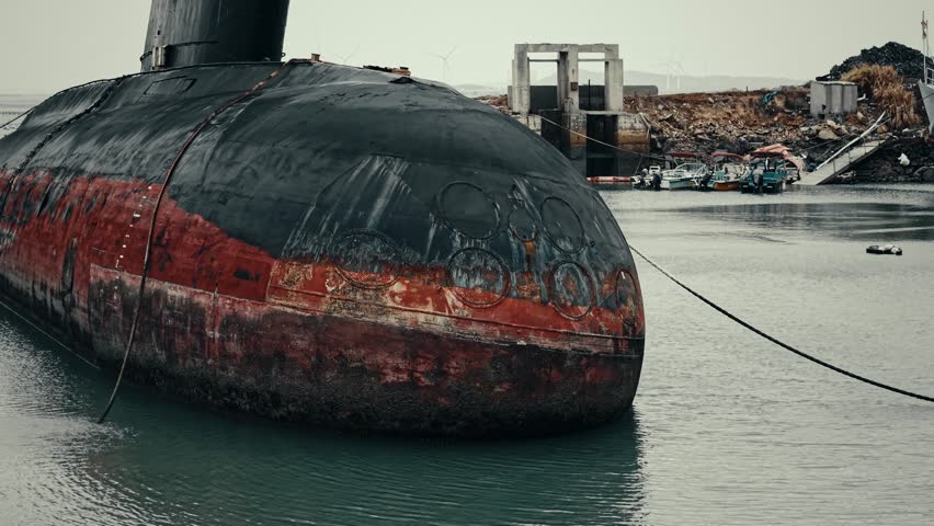 Submarino clase Kilo abandonado junto al mar. Tomas aéreas con dron y planos estáticos que muestran el casco y la torre desde distintos ángulos, con el agua y la costa de fondo. Ideal para documentales, historia naval y contenido industrial.