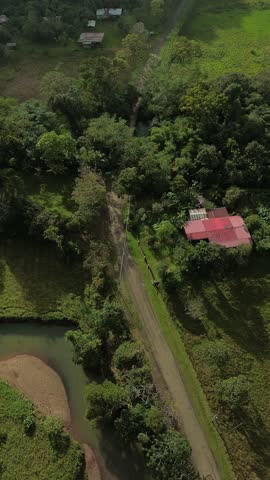 A rural area with a dirt road and a house in the distance