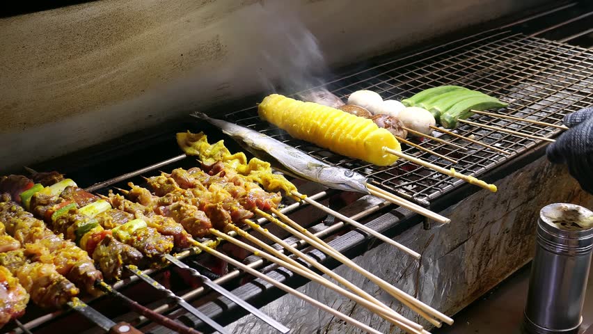 late-night food stall grilling lamb skewers and lamb chops and squid and potato tornado and other delicacies