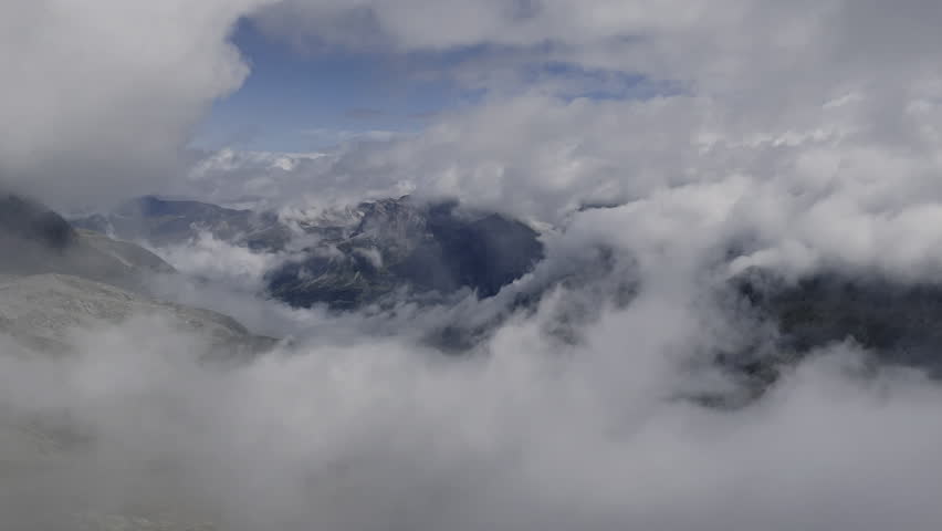 Clouds rising over rocky mountain peaks - Static Swiss Alps landscape