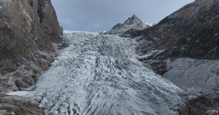 Beautiful high altitude hanging glacier and snow capped mountain with lake in Tibet, China