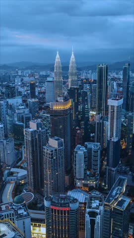 Kuala Lumpur, Malaysia – October 30, 2025: Aerial night view of Kuala Lumpur skyline featuring the iconic Petronas Twin Towers brightly illuminated above the city center, surrounded by modern skyscrapers and vibrant city lights, representing Malaysia’s rapid urban growth and global metropolis at night.